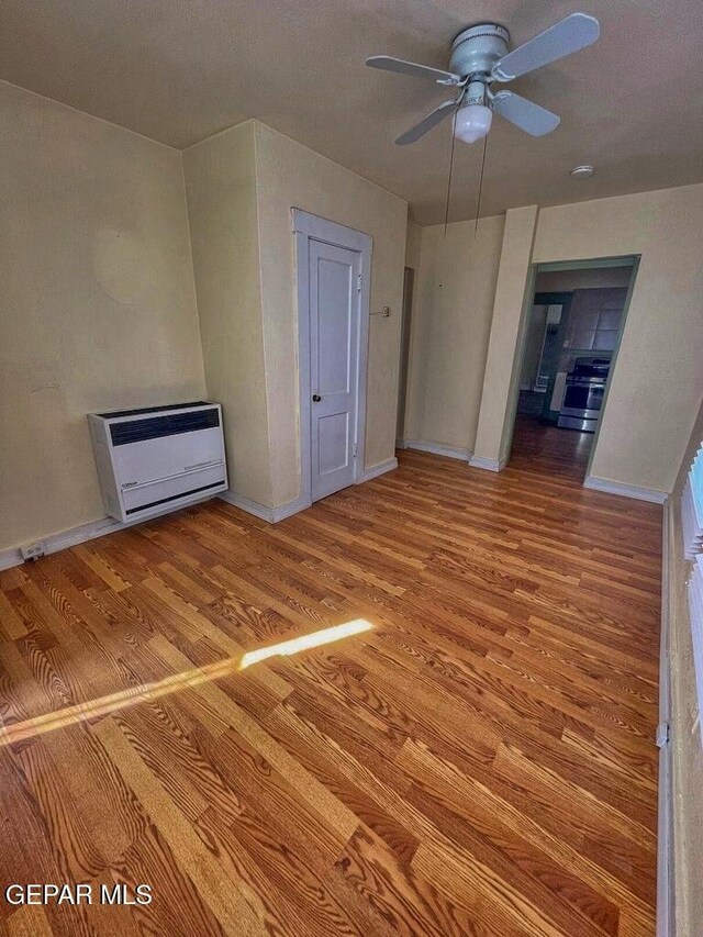 2526 Yandell Dr, El Paso, TX 79903 - spare room featuring wood finished floors, a ceiling fan, heating unit, and baseboards