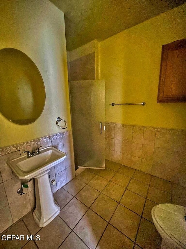 2526 Yandell Dr, El Paso, TX 79903 - bathroom featuring tile walls, toilet, tile patterned floors, a wainscoted wall, and a shower stall
