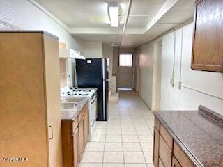 2526 Yandell Dr, El Paso, TX 79903 - kitchen with light tile patterned floors, dark countertops, and brown cabinets