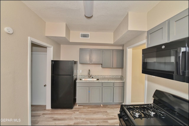 615 Arizona Ave, El Paso, TX 79902 - kitchen with black appliances, gray cabinetry, a sink, and a textured ceiling