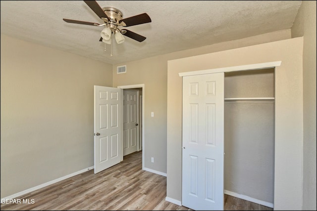 615 Arizona Ave, El Paso, TX 79902 - unfurnished bedroom with wood finished floors, a textured ceiling, a closet, baseboards, and ceiling fan