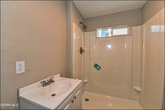 615 Arizona Ave, El Paso, TX 79902 - bathroom with a textured wall, a shower, and vanity