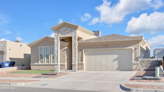12614 Amesbury, El Paso, TX 79928 - view of front of property featuring an attached garage, stucco siding, driveway, and stone siding