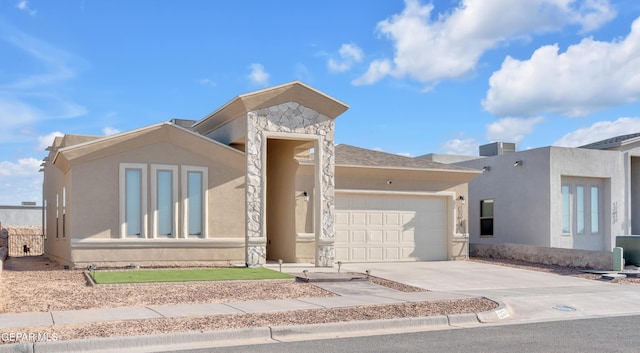 12614 Amesbury, El Paso, TX 79928 - view of front of house featuring an attached garage, driveway, stucco siding, and stone siding