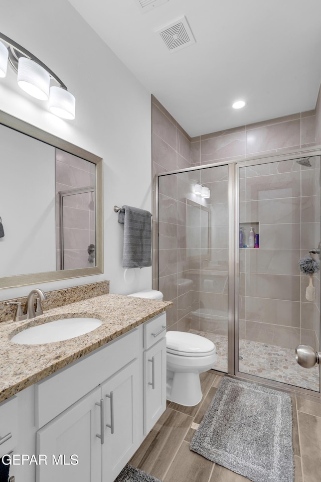 12614 Amesbury, El Paso, TX 79928 - bathroom featuring vanity, toilet, a shower stall, wood finished floors, and recessed lighting
