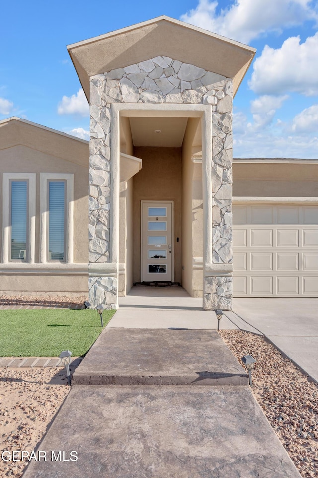 12614 Amesbury, El Paso, TX 79928 - property entrance featuring stucco siding, stone siding, and driveway