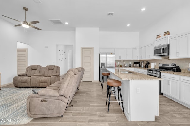 12614 Amesbury, El Paso, TX 79928 - kitchen with a sink, appliances with stainless steel finishes, open floor plan, ceiling fan, and a kitchen breakfast bar