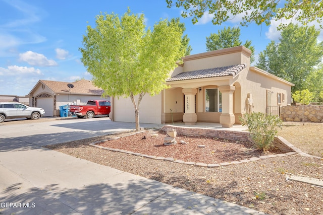11590 Flor Liatris Dr, Socorro, TX 79927 - view of front of house featuring concrete driveway, an attached garage, stucco siding, and a tiled roof
