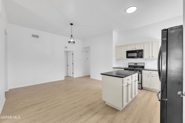 11590 Flor Liatris Dr, Socorro, TX 79927 - kitchen featuring black appliances, light wood finished floors, a center island, dark countertops, and backsplash