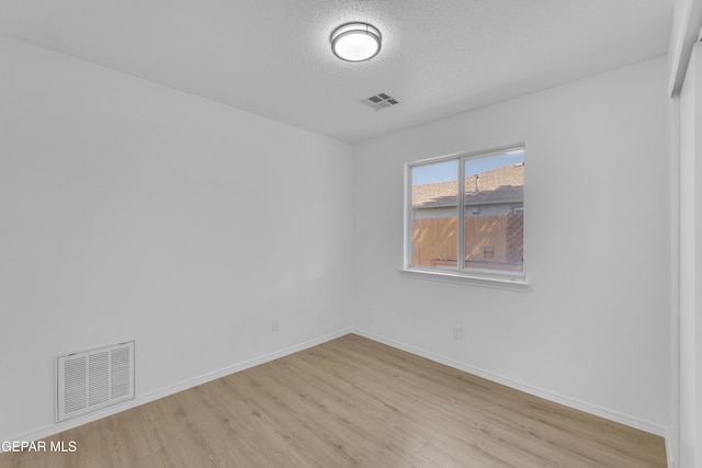11590 Flor Liatris Dr, Socorro, TX 79927 - empty room featuring light wood-type flooring, baseboards, and a textured ceiling