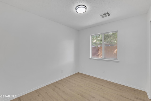 11590 Flor Liatris Dr, Socorro, TX 79927 - spare room with light wood-type flooring, baseboards, and a textured ceiling