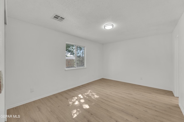 11590 Flor Liatris Dr, Socorro, TX 79927 - spare room featuring light wood-style flooring, baseboards, and a textured ceiling
