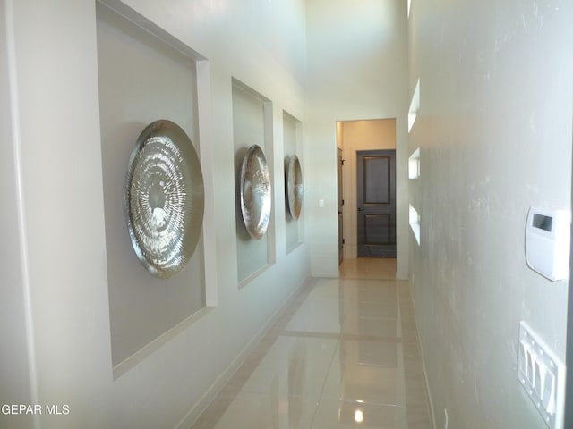 5868 Valley Palm Dr, El Paso, TX 79932 - hallway featuring tile patterned floors, baseboards, and a towering ceiling