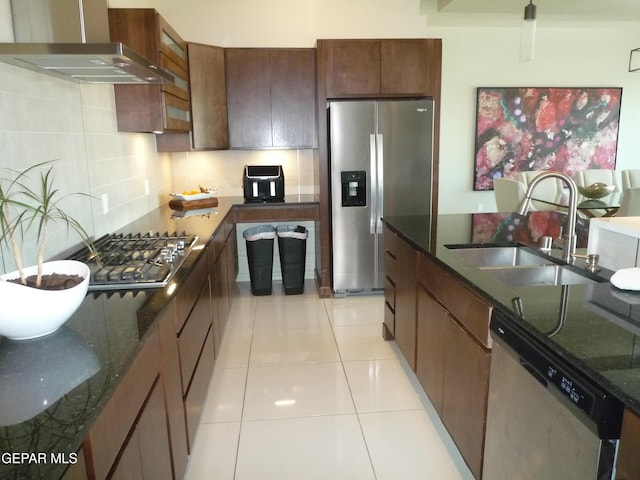 5868 Valley Palm Dr, El Paso, TX 79932 - kitchen featuring appliances with stainless steel finishes, wall chimney range hood, a sink, decorative backsplash, and dark stone counters