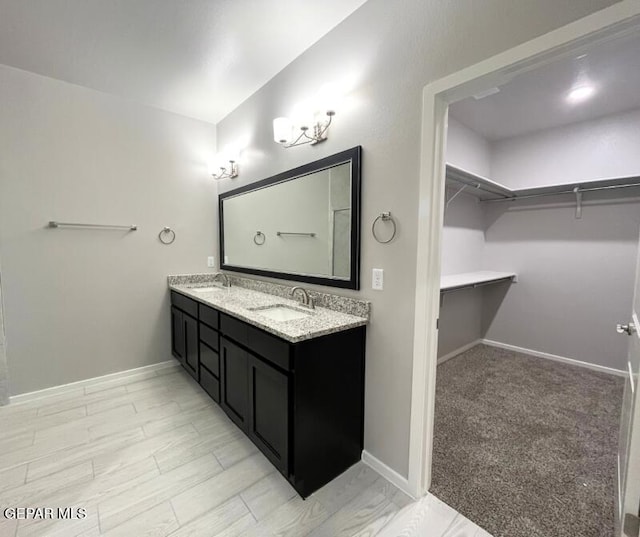 3800 Surmise St, El Paso, TX 79938 - bathroom featuring double vanity, a walk in closet, and baseboards