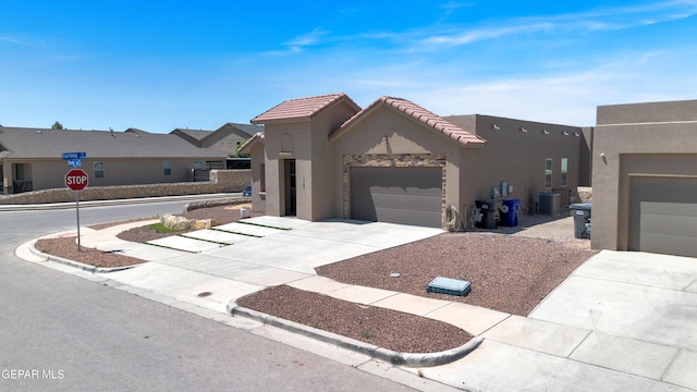 1741 Breeder Cup Way, El Paso, TX 79928 - view of front facade featuring driveway, stucco siding, cooling unit, an attached garage, and a tiled roof