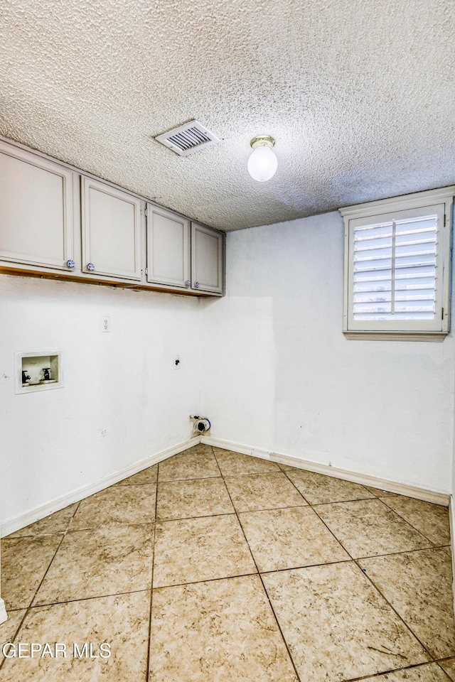 11513 Cree Ct, El Paso, TX 79936 - washroom with cabinet space, washer hookup, tile patterned flooring, electric dryer hookup, and a textured ceiling