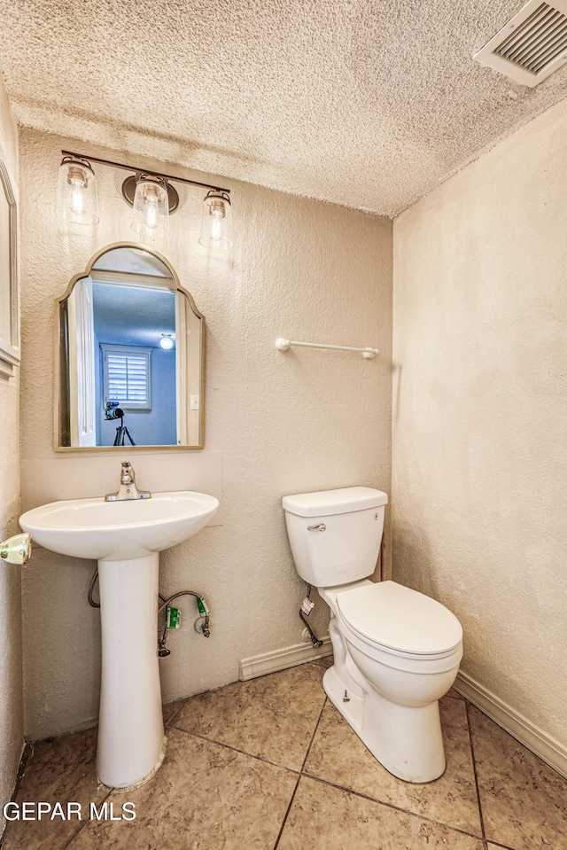 11513 Cree Ct, El Paso, TX 79936 - bathroom featuring toilet, a textured ceiling, and tile patterned floors