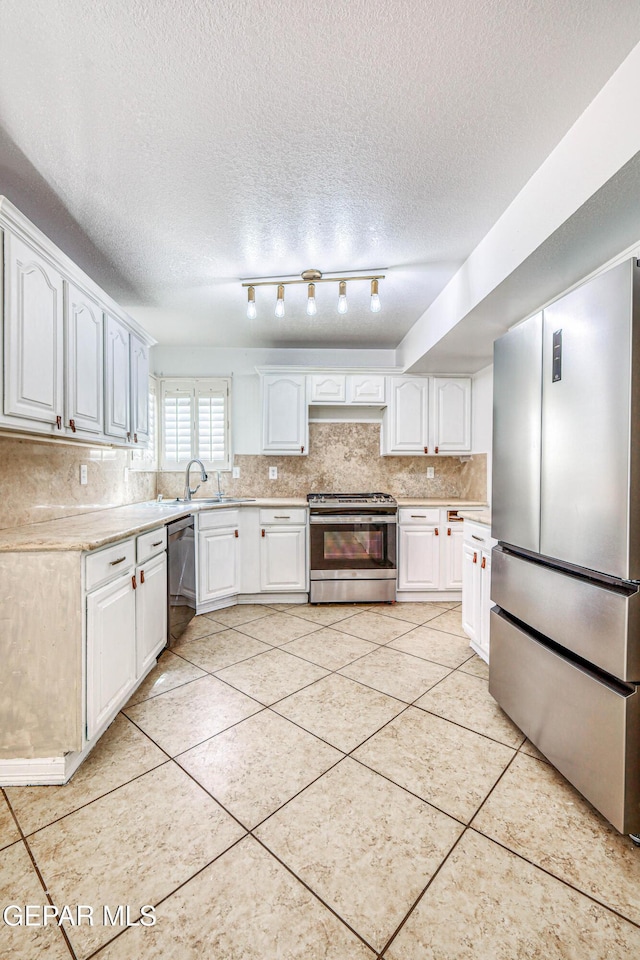 11513 Cree Ct, El Paso, TX 79936 - kitchen featuring appliances with stainless steel finishes, light countertops, tasteful backsplash, white cabinets, and a textured ceiling