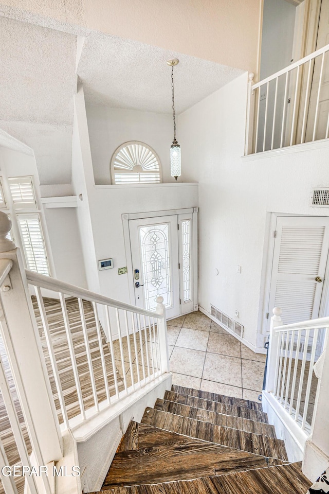 11513 Cree Ct, El Paso, TX 79936 - foyer with a textured ceiling, tile patterned flooring, plenty of natural light, a towering ceiling, and baseboards