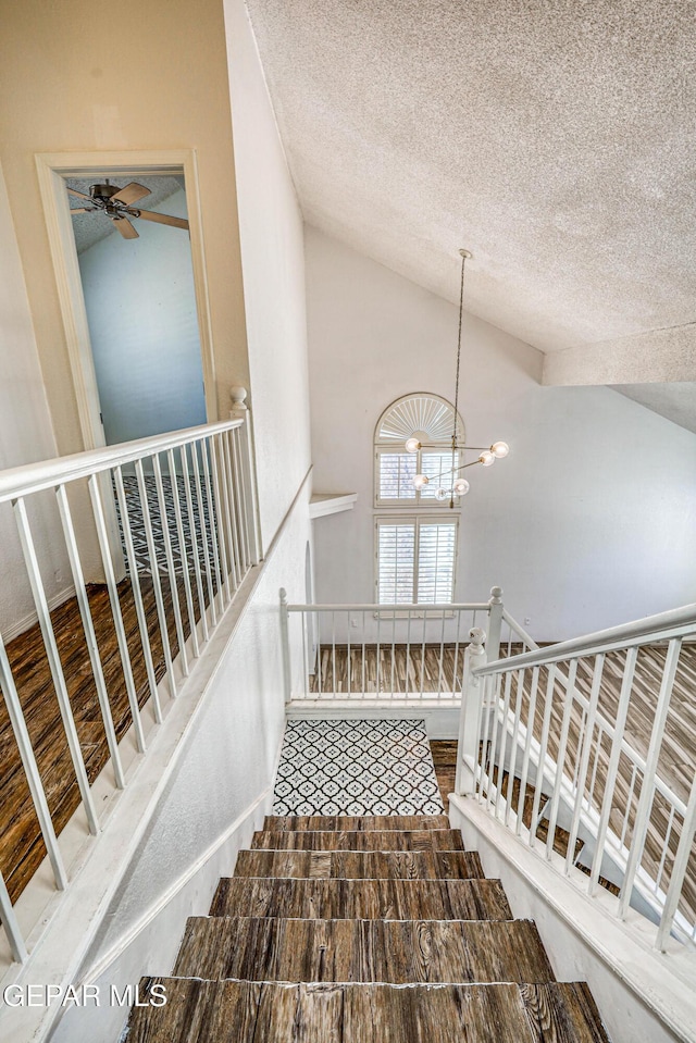 11513 Cree Ct, El Paso, TX 79936 - stairway with vaulted ceiling, a textured ceiling, a chandelier, and a ceiling fan
