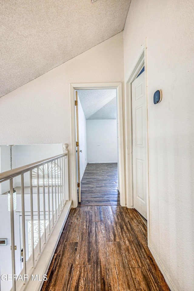 11513 Cree Ct, El Paso, TX 79936 - corridor with vaulted ceiling, wood finished floors, and a textured ceiling