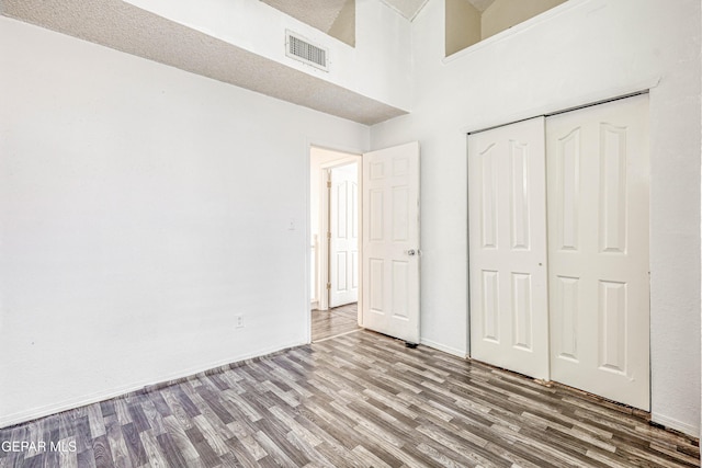 11513 Cree Ct, El Paso, TX 79936 - unfurnished bedroom featuring wood finished floors, a closet, a high ceiling, and baseboards