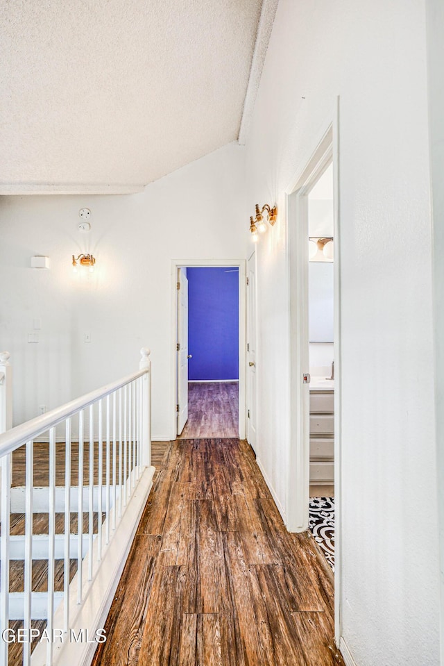 11513 Cree Ct, El Paso, TX 79936 - hall featuring wood finished floors, a textured ceiling, lofted ceiling, and an upstairs landing
