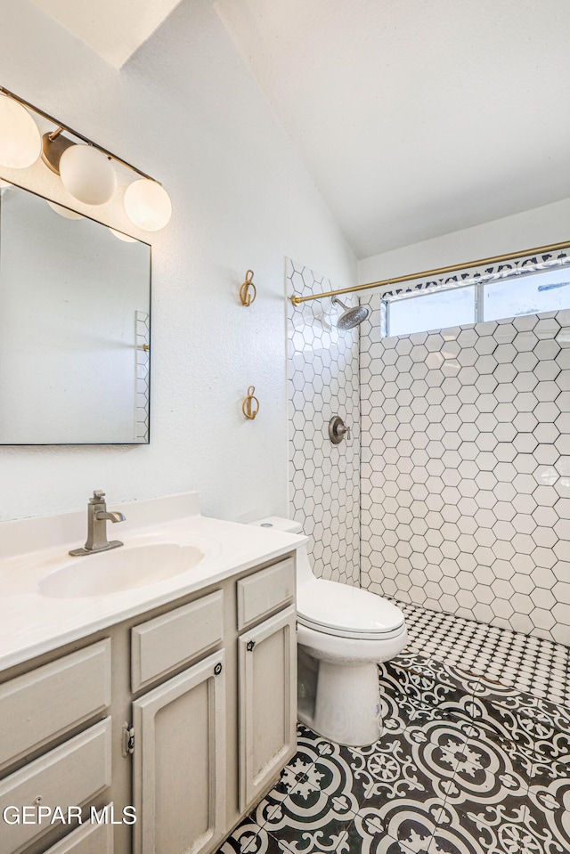 11513 Cree Ct, El Paso, TX 79936 - full bathroom featuring vanity, a tile shower, toilet, and lofted ceiling