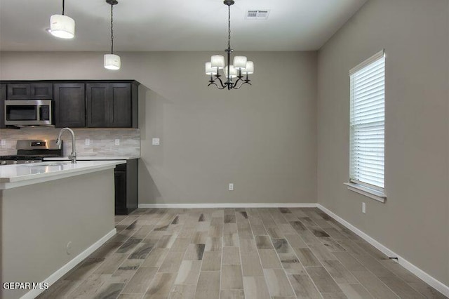3804 Surmise St, El Paso, TX 79928 - kitchen with appliances with stainless steel finishes, backsplash, light wood-style floors, and light countertops