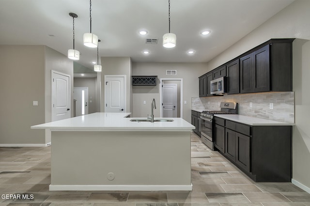 3804 Surmise St, El Paso, TX 79928 - kitchen with stainless steel appliances, a sink, wood finish floors, tasteful backsplash, and a center island with sink