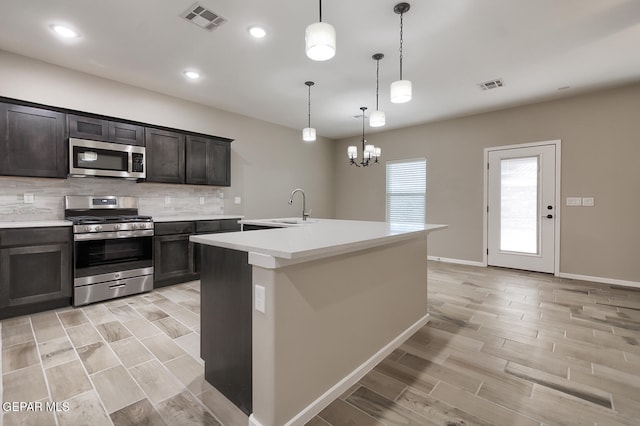 3804 Surmise St, El Paso, TX 79928 - kitchen with appliances with stainless steel finishes, a sink, wood tiled floors, backsplash, and light countertops