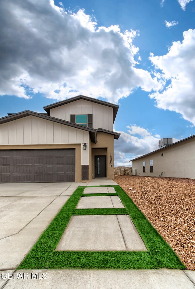 3804 Surmise St, El Paso, TX 79928 - view of front facade with concrete driveway, an attached garage, and board and batten siding