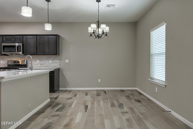 3804 Surmise St, El Paso, TX 79928 - kitchen featuring appliances with stainless steel finishes, light countertops, decorative backsplash, a chandelier, and plenty of natural light