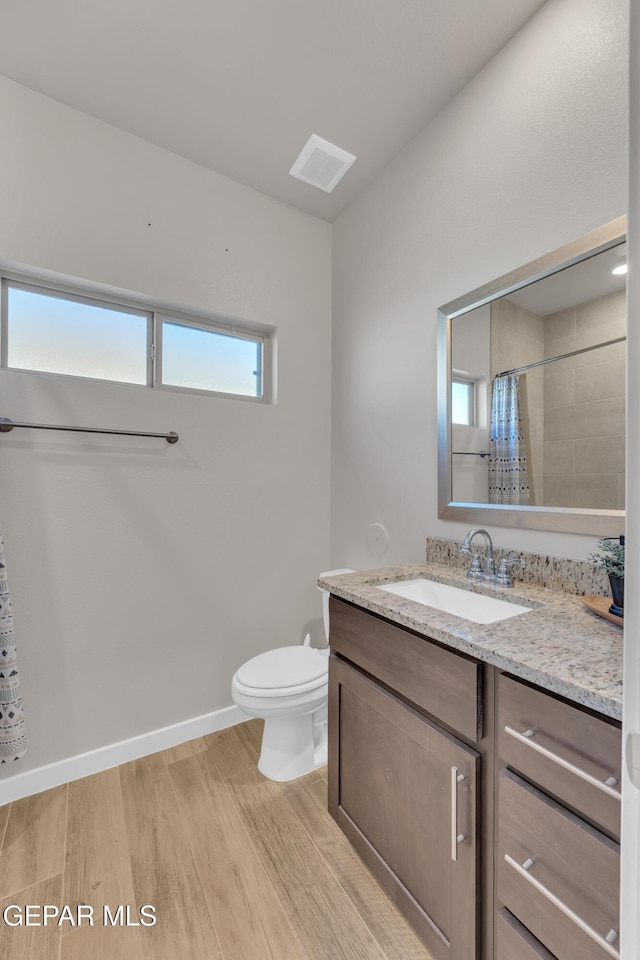 13676 Lago Vista Ave, Horizon City, TX 79928 - bathroom with vanity, wood finished floors, toilet, and curtained shower