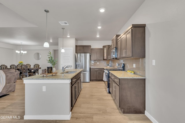 13676 Lago Vista Ave, Horizon City, TX 79928 - kitchen featuring stainless steel appliances, a sink, light wood-type flooring, backsplash, and light stone counters