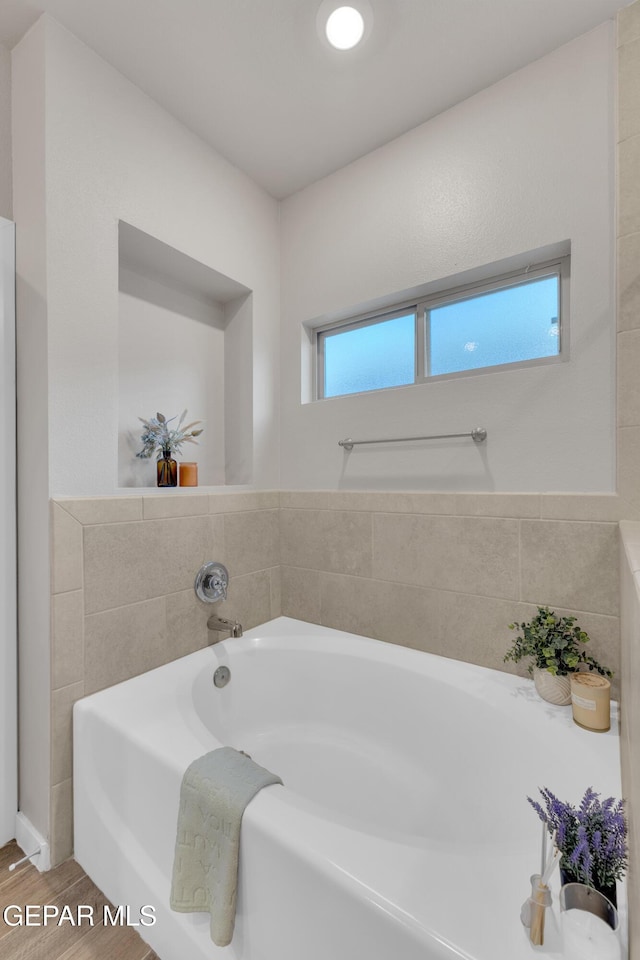 13676 Lago Vista Ave, Horizon City, TX 79928 - bathroom featuring a garden tub and wood finished floors
