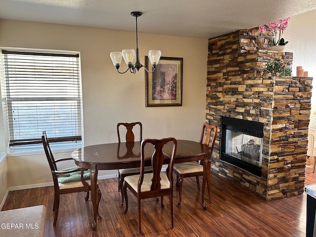11048 Nathan Bay Dr, El Paso, TX 79934 - dining area featuring wood finished floors, baseboards, a chandelier, and a stone fireplace
