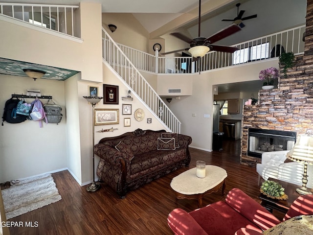 11048 Nathan Bay Dr, El Paso, TX 79934 - living room featuring a ceiling fan, a towering ceiling, wood finished floors, a stone fireplace, and baseboards