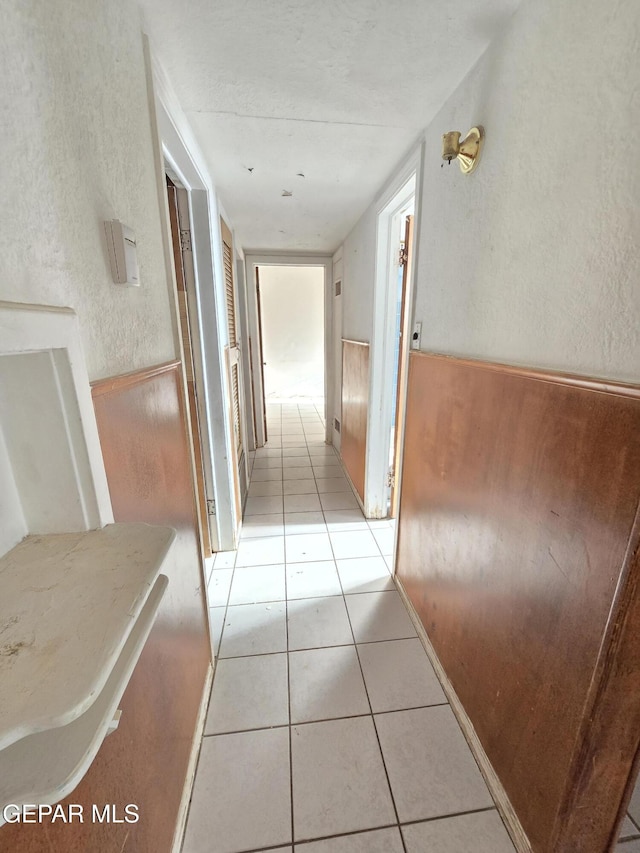 371 Medina St, El Paso, TX 79905 - corridor featuring light tile patterned floors, a textured wall, and a wainscoted wall