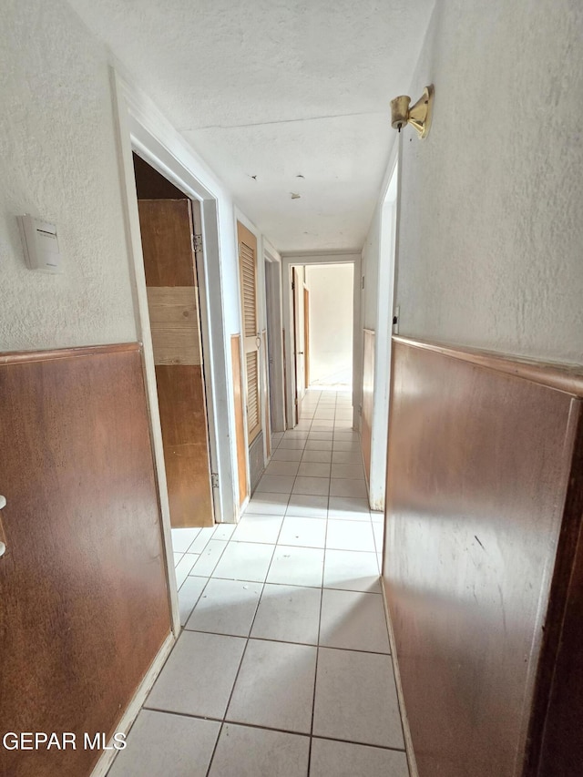 371 Medina St, El Paso, TX 79905 - corridor featuring light tile patterned floors, a textured wall, and wainscoting