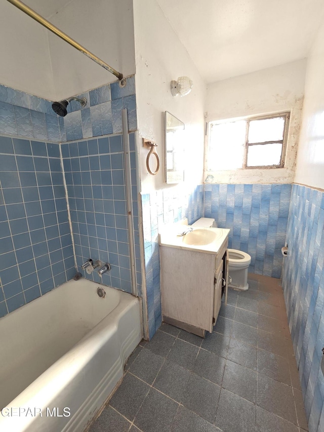 371 Medina St, El Paso, TX 79905 - full bathroom with toilet, vanity, tub / shower combination, tile patterned floors, and a wainscoted wall