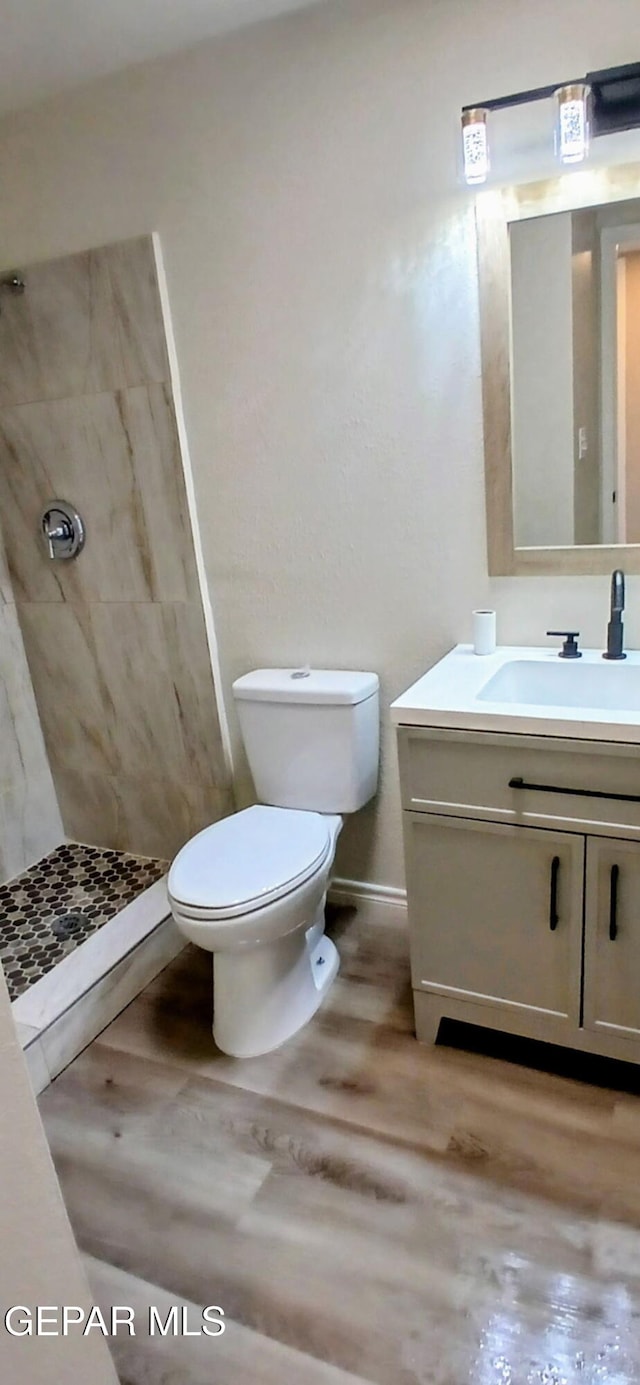 338 Maricela Dr, El Paso, TX 79915 - bathroom featuring a shower stall, toilet, vanity, wood finished floors, and baseboards
