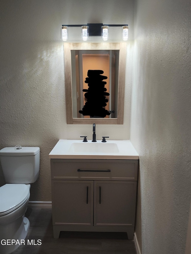 338 Maricela Dr, El Paso, TX 79915 - half bathroom with vanity, wood finished floors, baseboards, and toilet