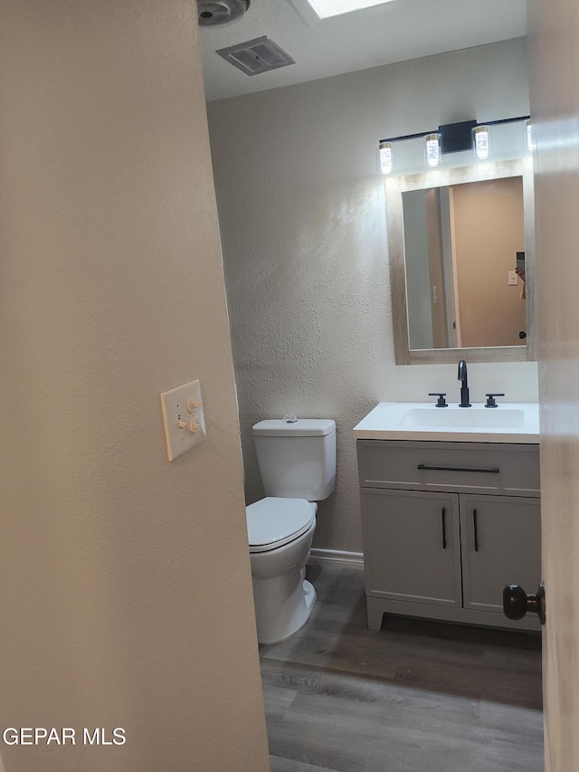 338 Maricela Dr, El Paso, TX 79915 - bathroom featuring wood finished floors, vanity, toilet, baseboards, and a textured wall