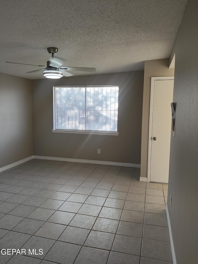 338 Maricela Dr, El Paso, TX 79915 - empty room featuring healthy amount of natural light, a textured ceiling, ceiling fan, light tile patterned floors, and baseboards