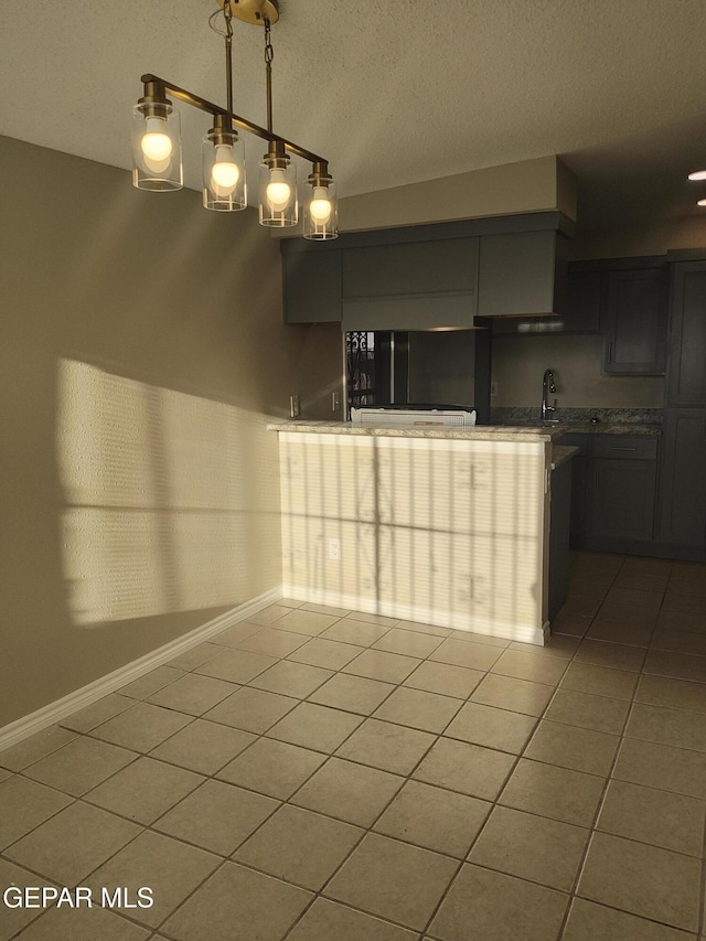 338 Maricela Dr, El Paso, TX 79915 - unfurnished dining area featuring light tile patterned flooring, a textured ceiling, baseboards, and a sink