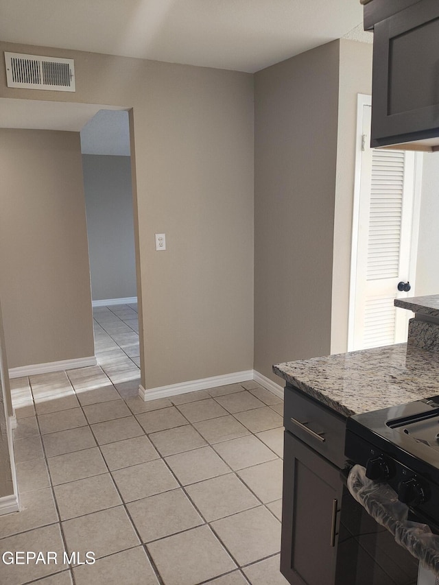 338 Maricela Dr, El Paso, TX 79915 - kitchen with range, light tile patterned flooring, light stone countertops, and baseboards