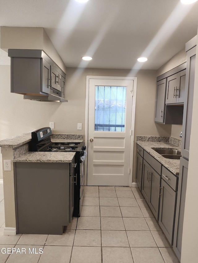338 Maricela Dr, El Paso, TX 79915 - kitchen featuring stainless steel gas range oven, a sink, gray cabinetry, light tile patterned flooring, and under cabinet range hood