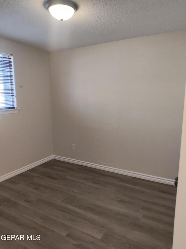 338 Maricela Dr, El Paso, TX 79915 - unfurnished room featuring dark wood-style flooring, baseboards, and a textured ceiling